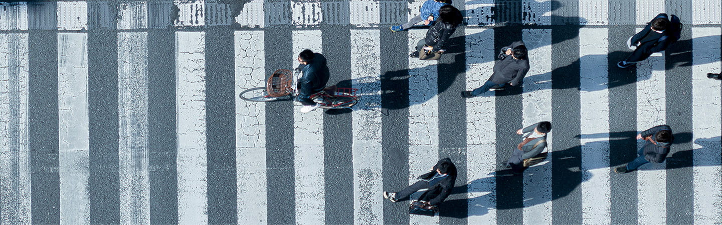 Cyclist and pedestrians walking on zebra crossing